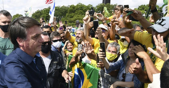 Bolsonaro, sem máscara, aperta a mão de seus seguidores (24/5) Sergio LIMA / AFP